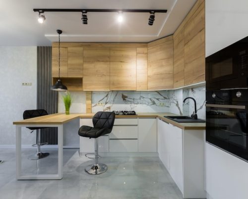 interior-modern-kitchen-with-bar-with-wooden-inserts-white-marble-tiles-small-apartment_321831-7272