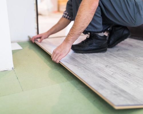 worker-processing-floor-with-laminated-flooring-boards_231208-4211
